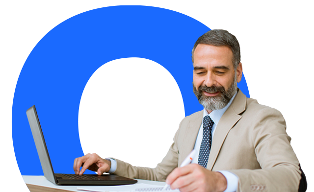 A person working on a laptop and writing in a notepad