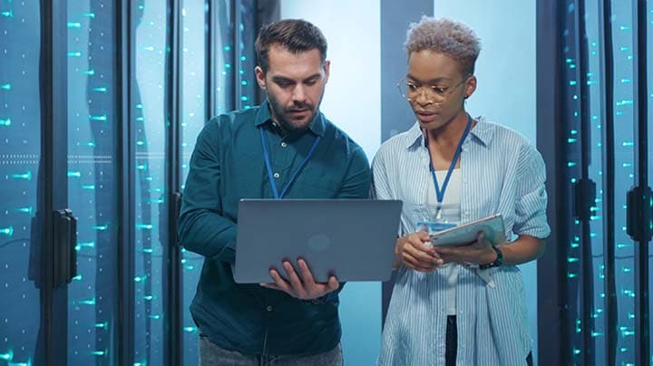 Two people working on a laptop 