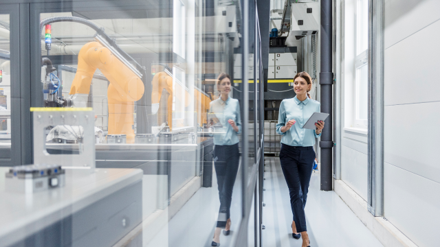 A woman walking through factory holding tablet