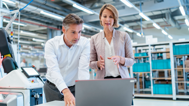 two people reviewing content on a laptop